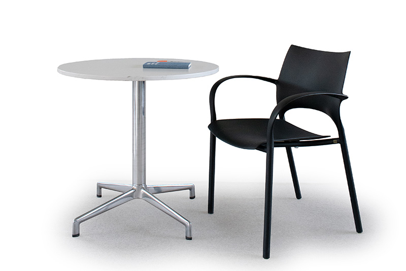 Loon arm chair next to the Juxta LE round conference height table